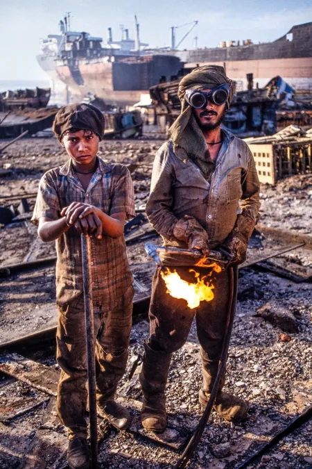 Ein Gascutter mit seinem jugendlichen Helfer auf der weltgrößten Abwrackwerft in Alang, Indien, fotografiert für Geo, 2020 © Rolf Nobel